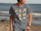 Graphic on a grey t-shirt featuring multiple cute corgis painting on canvases.