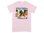 Dog running with a ball on a pink t-shirt with "Always Operating At Full Capacity".