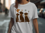 Three brown dogs with distinct collars and features sit in a line on a white t-shirt.