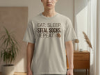Light tan t-shirt with text "EAT. SLEEP. SOCKS. REPEAT." and dog icon.