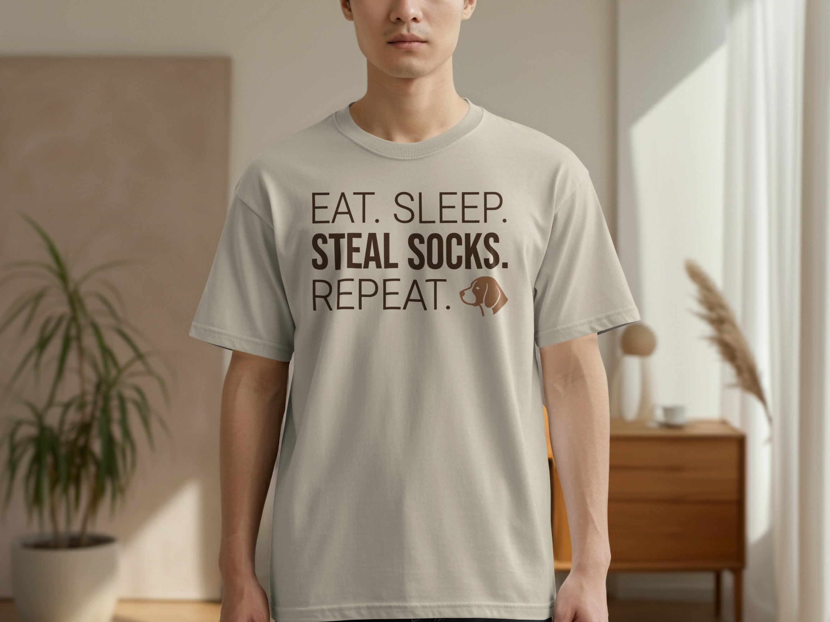 Light tan t-shirt with text "EAT. SLEEP. SOCKS. REPEAT." and dog icon.