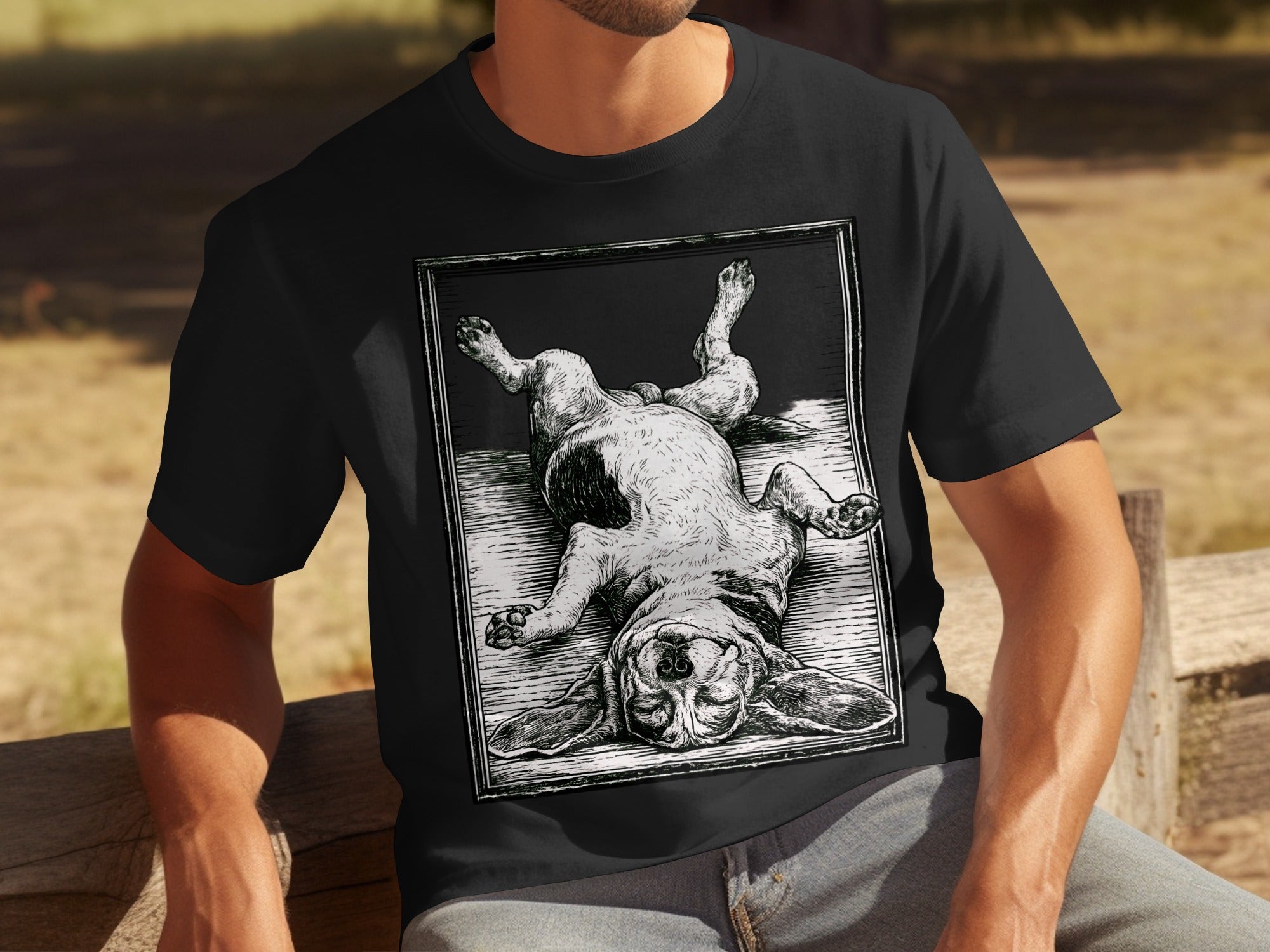 Black t-shirt with woodcut print of a basset hound lying on its back.