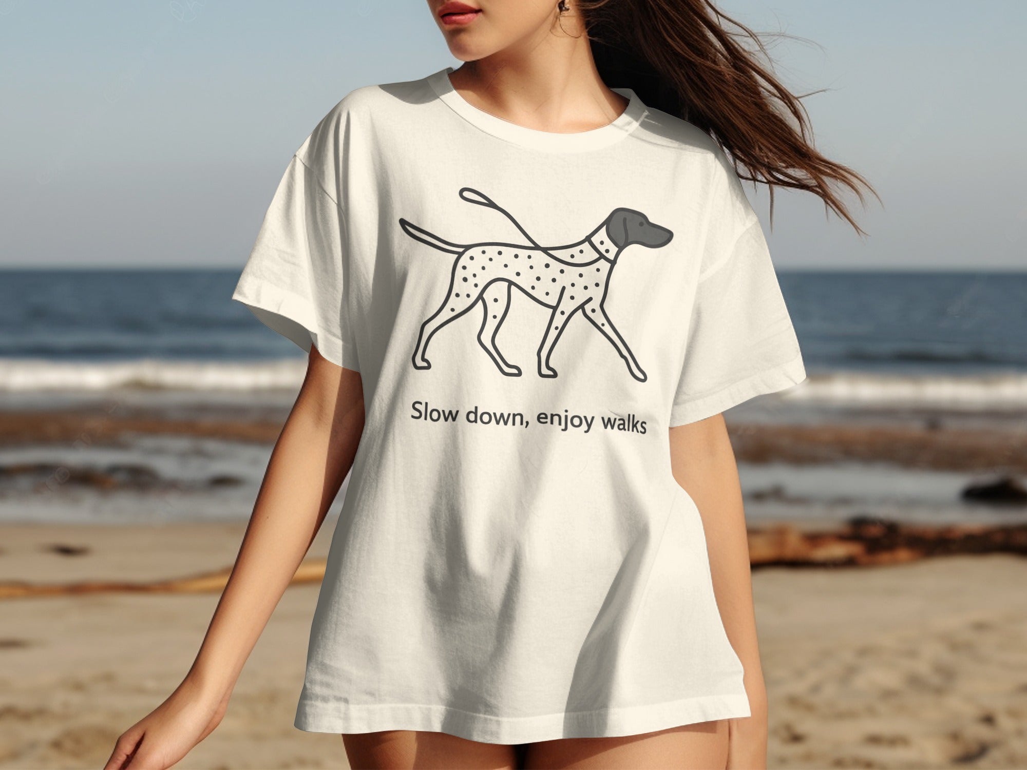White t-shirt with a doodle of a Dalmatian dog and text "Slow down, enjoy walks"