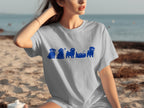 Light blue t-shirt with blue pug illustrations in various poses on a beach.