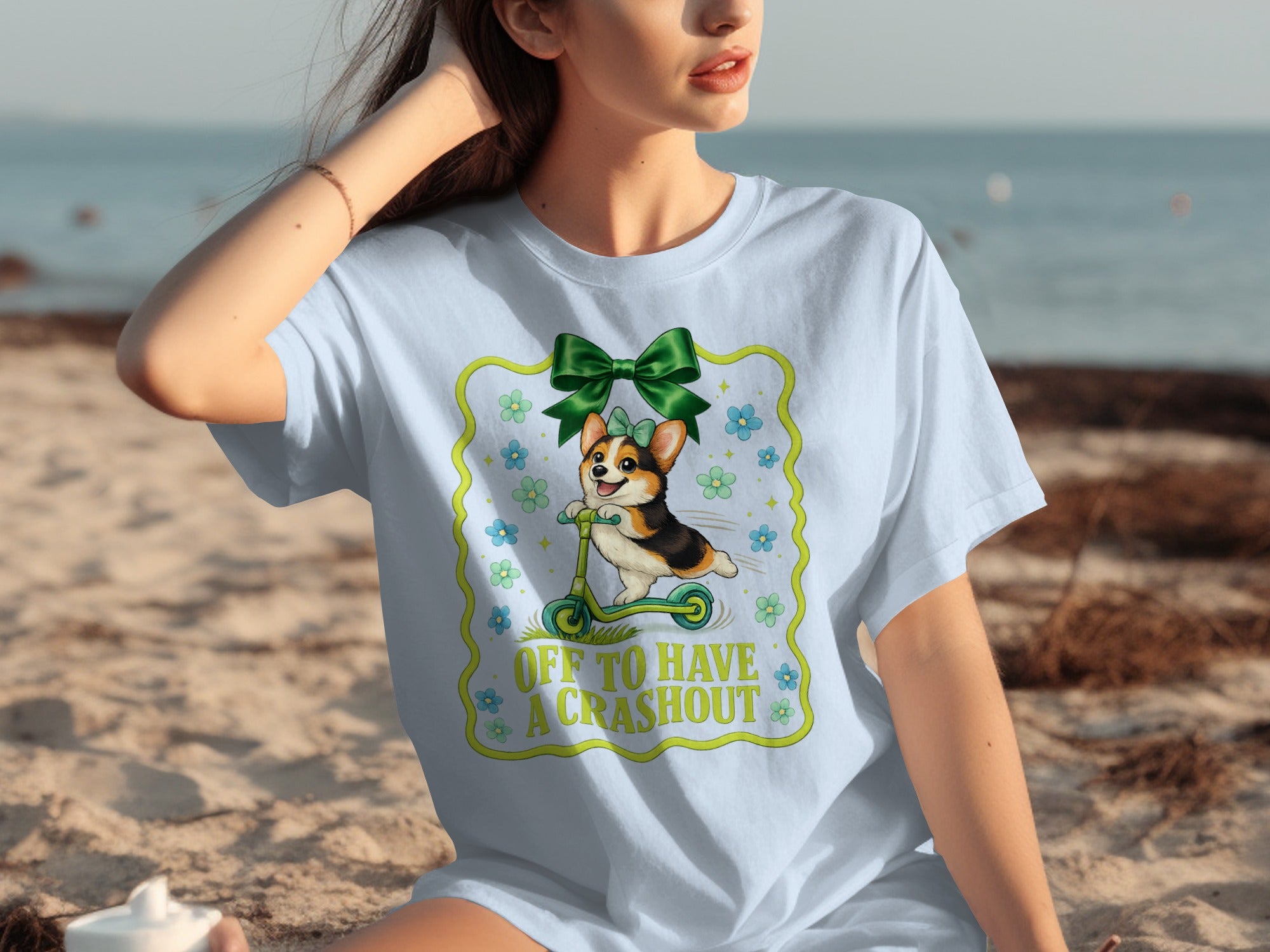 Light blue t-shirt with a corgi riding a scooter, text "OFF TO HAVE A CRASHOUT."