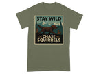 T-shirt graphic with a brown dog chasing a squirrel in a forest scene, text reads "STAY WILD CHASE SQUIRRELS".