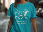 Teal t-shirt with white line drawing of a dog and text "Slow down, enjoy walks."