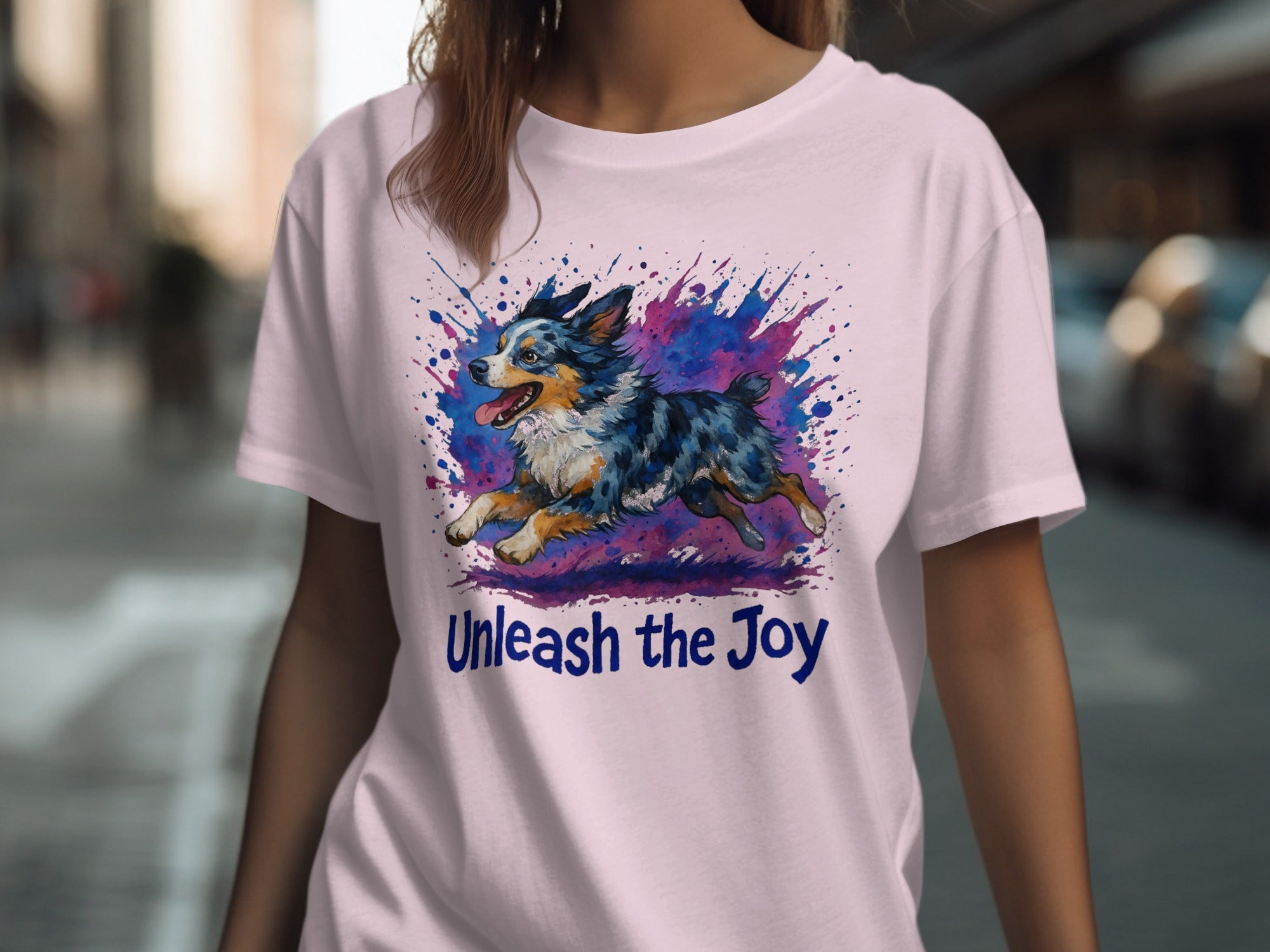 T-shirt with blue and pink paint splatter design featuring a running dog and text "Unleash the Joy".