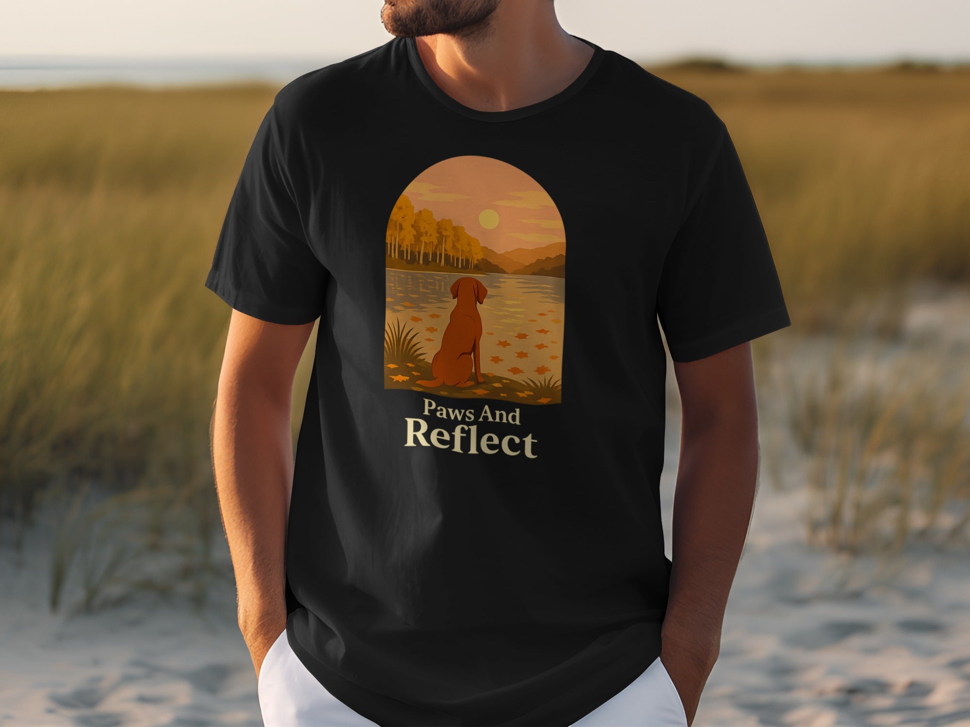 Black t-shirt with a sunset scene and a dog with text "Paws And Reflect."