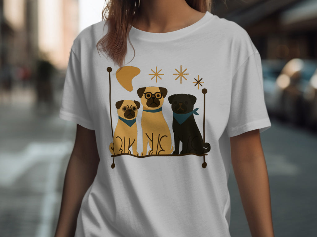 Three pugs sit on a line, one wearing glasses, on a white t-shirt.