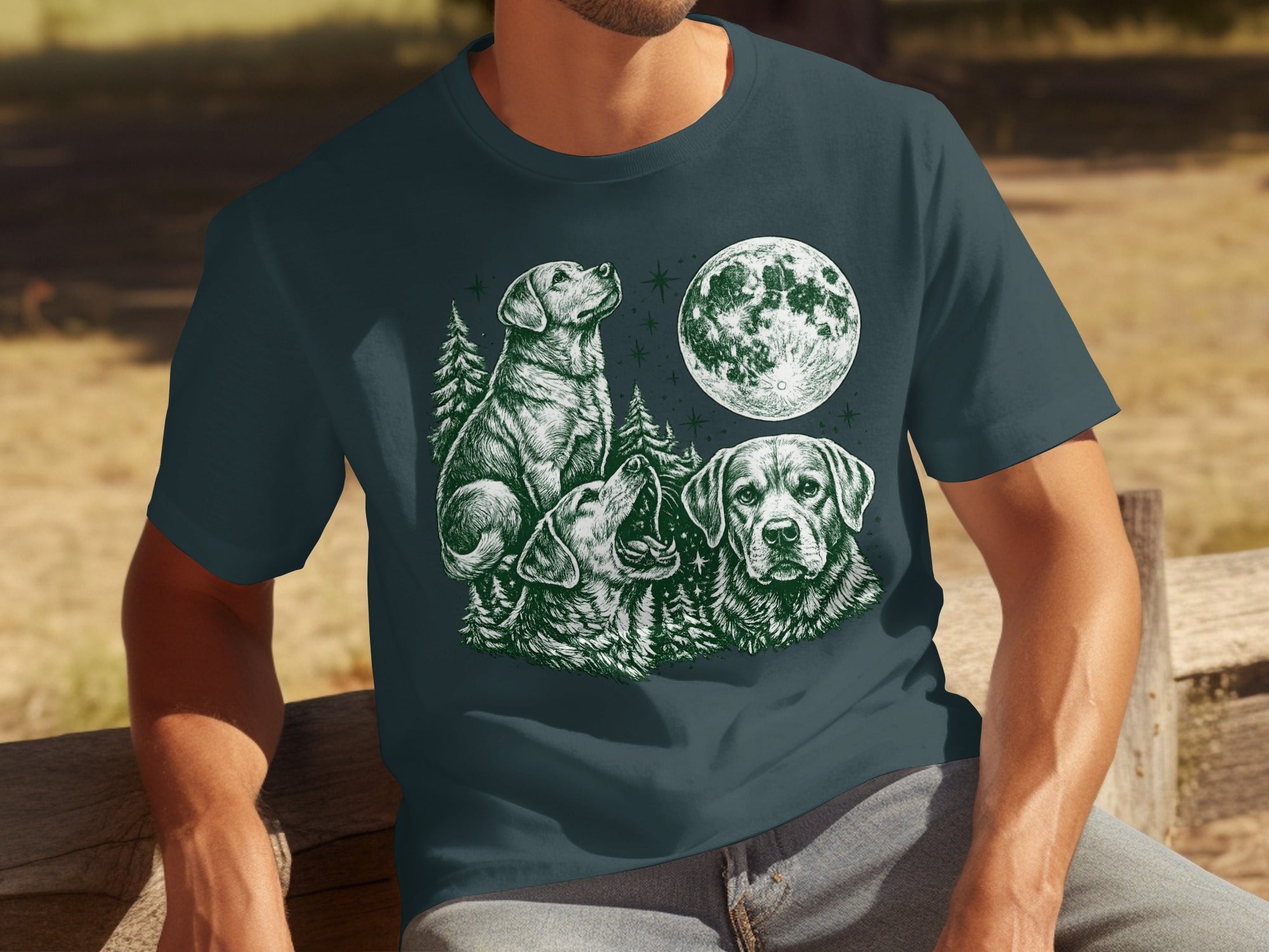 T-shirt with green sketch of three dogs under a moon and pine trees.