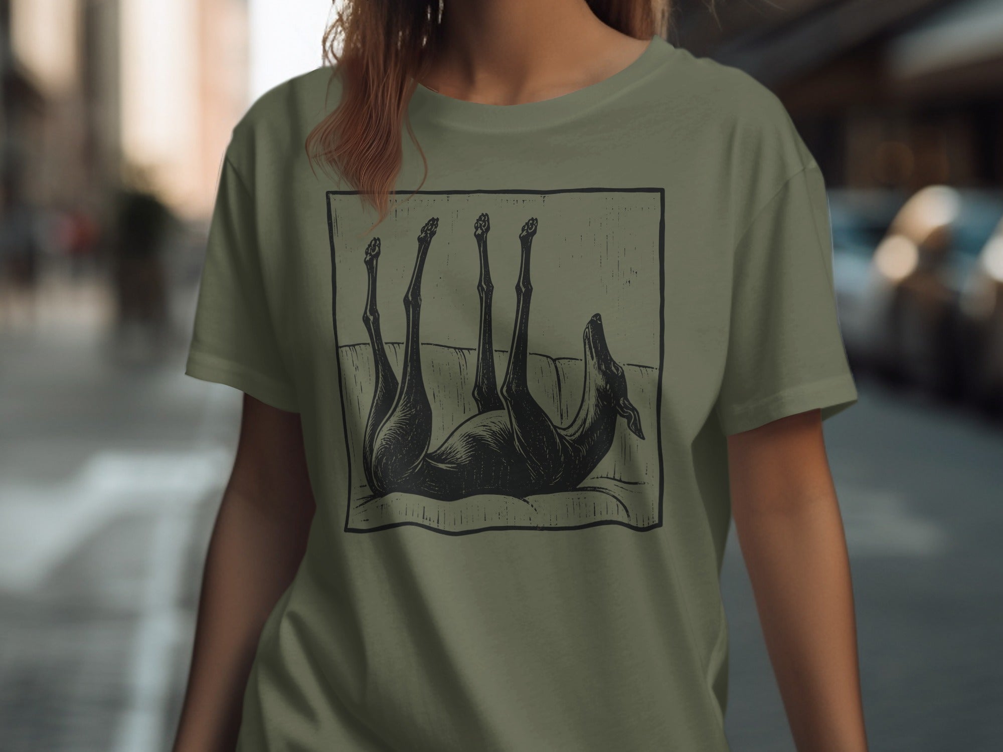 Dog on couch graphic on olive green t-shirt.