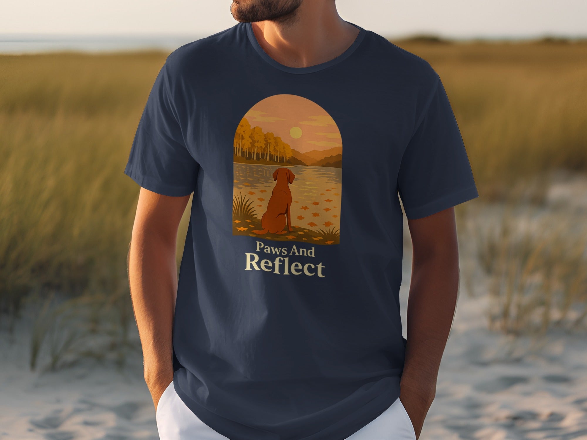 Navy t-shirt with screen print of dog by water and text "Paws And Reflect".