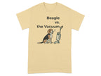 Beagle sits warily before a vacuum cleaner on a tan t-shirt.